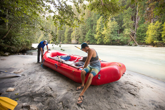 Two guides work to inflate raft before a whitewater river trip.