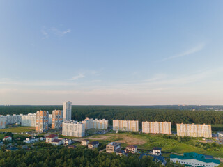Fototapeta premium Top view of the city, landscape and buildings, sky and silhouettes of houses from the height of a flying drone. 