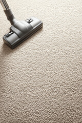 Close-up of a vacuum cleaner on a fluffy carpet, showcasing home cleaning and maintenance