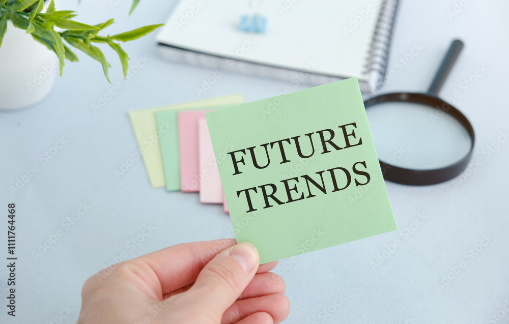 Poster future trends text on a sheet in hands on a desktop background