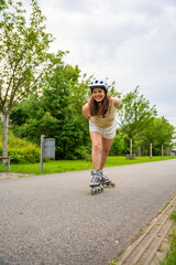 Roller skater woman in park rollerblading on inline skates. Outdoor activities. Summer roller...