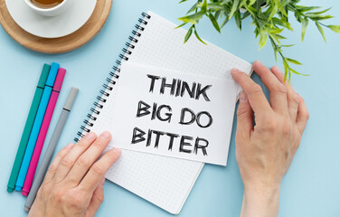 Notepad with text Think Big Do Bigger. Diagram and white background