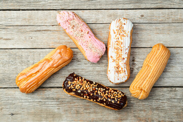 Assorted eclairs on a pastel top view Traditional French dessert