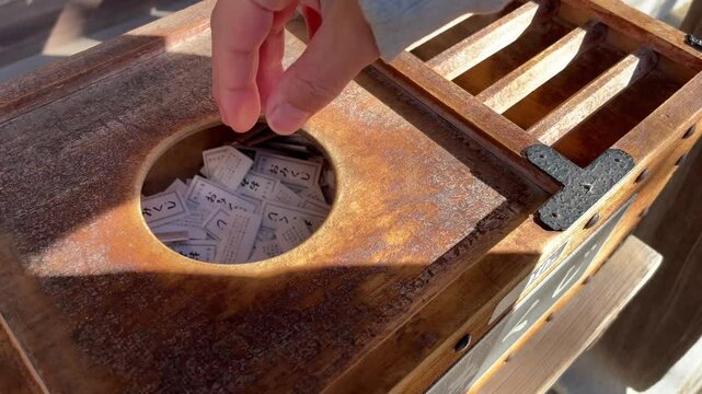 神社でおみくじを引く男性　新年の初詣で運試し