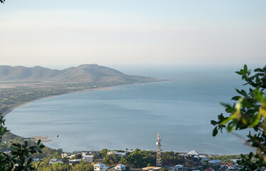 A bay with headland protruding on a clear but hazy day with blue ocean water