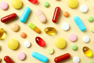 Various pills and capsules on a color background