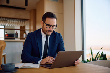 Fototapeta premium Businessman working on laptop while sitting in café.