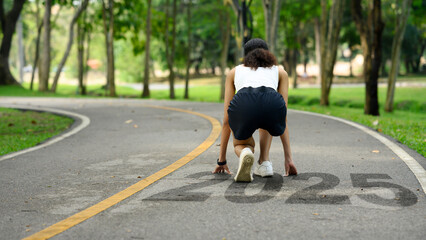 Back view of athlete woman in starting position ready for sprint. 2025 Goals and new beginning and...