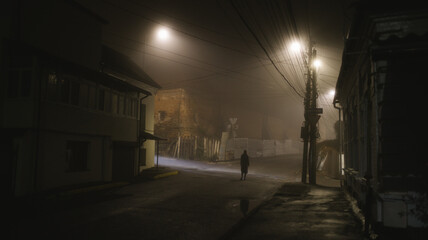 Woman walking alone on a foggy night in the city