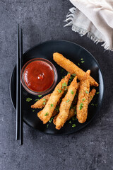 Breaded Torpedo shrimps on black slate background