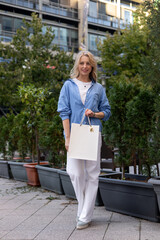 Young woman walking down street with bags after shopping. Shopping in the mall