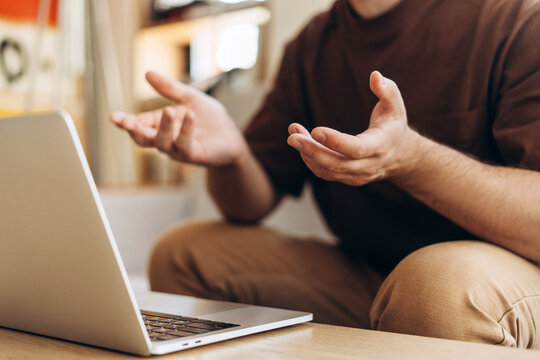 Closeup, freelancer, businessman using laptop, having video conference, selective focus on hands