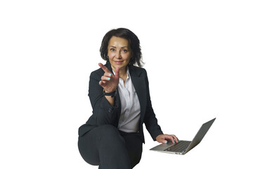 adult female brunette businesswoman in a jacket is sitting typing on a laptop and gesturing with her fingers