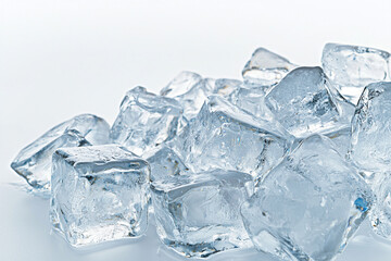 Clear ice cubes scattered on a white surface in soft light