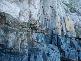 Fototapeta premium Kullaberg, rock formations - The vibrant rock formations of Kullaberg, Sweden, reveal nature's forces and a history of smuggling, impressively viewed from the water.