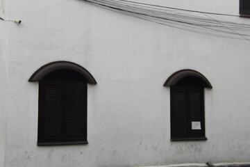 Close-up of a window on the wall of a house, showcasing its architectural design and texture. Perfect for themes of housing, construction, minimalism, or exterior decor in residential properties.

