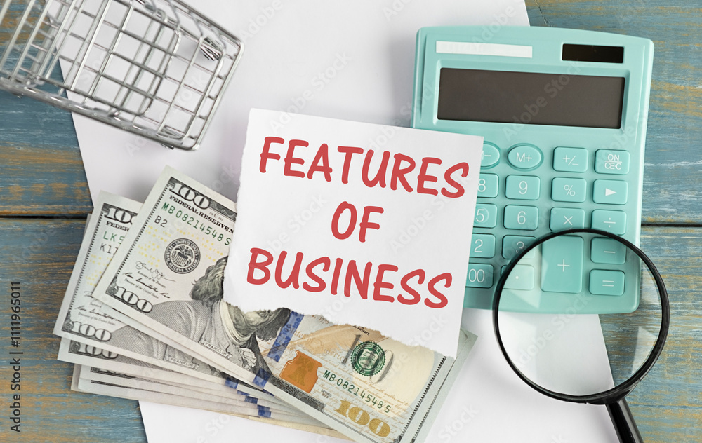 Poster calculator with notebook with text feature of business on wooden background