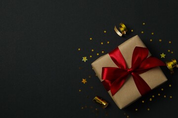 Beautiful gift box tied with bow on black background 