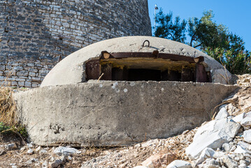 A close-up of a military concrete bunker or pillbox in southern Albania built by Enver Hoxha's communist government. Big bunker on background of Lekuresi Castle, Saranda.