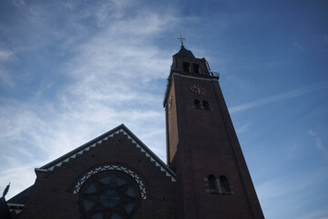 Historic church tower under a blue sky in Noord-Brabant, Nederland, showcasing architectural beauty in tranquility