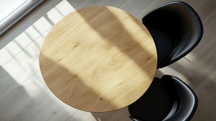 A sleek round wooden table with two black modern chairs, featuring soft shadows from natural light.