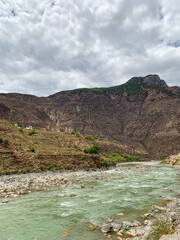 Views of Tibetan houses, green field and mountains along the road from Shangri La to Yading, Sichuan 