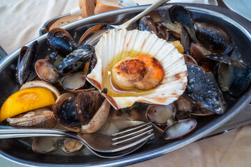A delicious Mediterranean dish of various types of mussels with garlic sauce, served on a platter...