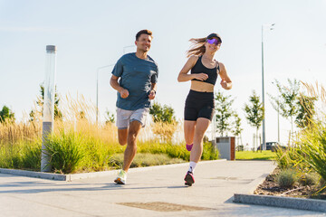 Two joggers enjoying a sunny day in a park while maintaining their fitness routine