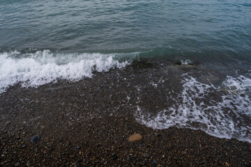 Water sea beach. Wave ocean blue. Stone texture reflection sun. Surface coast pebbles. 