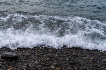 Obraz premium Water sea beach. Wave ocean blue. Stone texture reflection sun. Surface coast pebbles. 