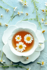 Chamomile flower tea. A tea cup with infusing blossoms, overhead flat lay shot, an organic home infusion