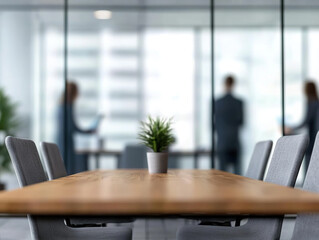 modern office meeting space featuring wooden table, potted plant, and blurred figures in background. atmosphere is professional and inviting