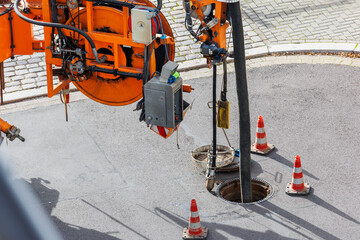 Pipe hose sewage truck car engine emptying city street sewerage manhole. Septic cleaning vacuum...