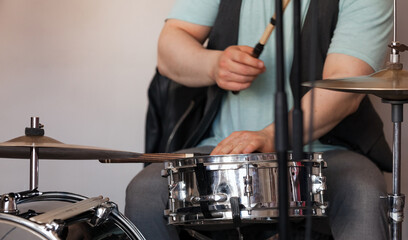 Drummer plays a snare drum and cymbals, closeup photo