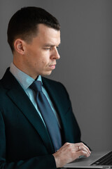 Successful smiling ambitious caucasian european businessman lawyer in suit standing in light office with laptop and phone