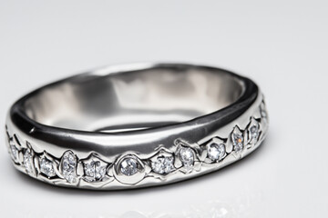 A wedding ring with diamonds on a white background. A gray ring with a silver background. Silver...