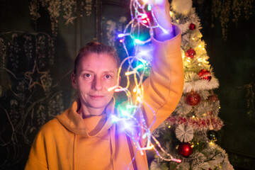 woman hanging up colorful Christmas lights