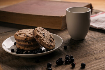 Home made Chocolate Cookies with Blueberries and Milk on Wooden table