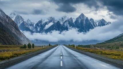 Fototapeta premium Serene Mountain Road Under Dramatic Cloudy Sky and Majestic Peaks