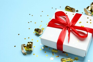 Beautiful gift box tied with bow on color background 