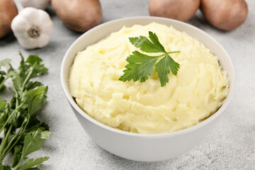 Mashed potatoes in white bowl on grey concrete background. Healthy food