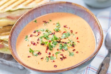 Bowl with Red bell pepper creamy soup, horizontal closeup