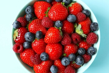 Different fresh ripe berries in bowl on the table