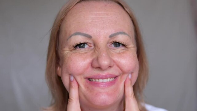 sad woman face girl helps with fingers to make smile concept of massage under face cups good mood self-massage gymnastics for face
