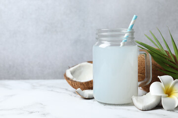 Mason jar with coconut water with nuts on wooden table
