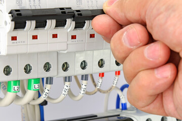 The hand turns on the handle of the automatic current switch. Close-up. Soft focus.