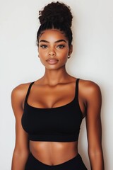 Fototapeta premium A woman with a black tank top and a ponytail. She has a very nice look on her face
