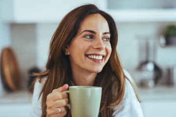 Smiling Woman Enjoying a Relaxing Moment With a Cup of Coffee