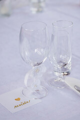 Wedding table with detail of glasses, cutlery and signs with name tags in the Czech language