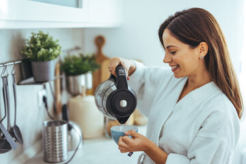 Smiling Woman in White Robe Making Morning Coffee in Modern Kitchen